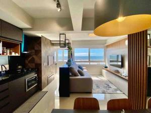 uma ampla sala de estar com um sofá e uma cozinha em A melhor vista de Capão da Canoa em Capão da Canoa