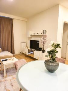 ein Wohnzimmer mit einem Tisch mit einer Vase darauf in der Unterkunft Belgrade Waterfront - Beograd na vodi Lux Apartman in Belgrad + 27 Fotos