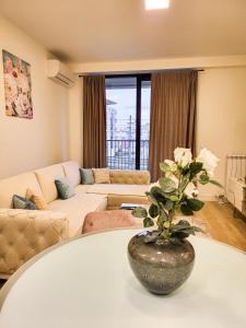 ein Wohnzimmer mit einer Vase auf einem Tisch in der Unterkunft Belgrade Waterfront - Beograd na vodi Lux Apartman in Belgrad