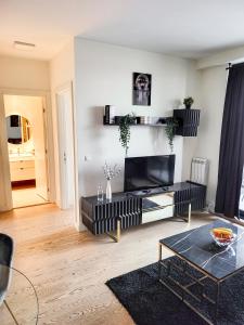 ein Wohnzimmer mit einem Flachbildfernseher an der Wand in der Unterkunft Belgrade Waterfront - Beograd na vodi Lux Apartman in Belgrad