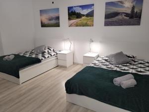 a bedroom with two beds and pictures on the wall at Apartament BESKIDLOVE in Węgierska Górka +40 photos