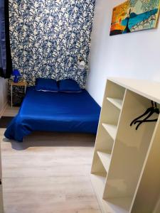 een slaapkamer met een blauw bed en een bureau bij T2 entre rivière et château centre Vitré in Vitré