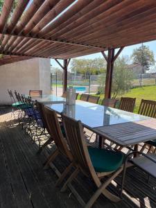 una mesa y sillas en una terraza con piscina en Maison de rêve, en Boulogne-sur-Gesse