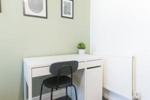 a white desk with a black chair next to it at Poppy's Project - July Road in Liverpool
