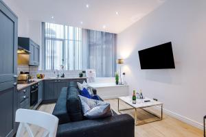 a living room with a couch and a kitchen at Modern 2-bedroom Apt In The Heart Of City Centre in Liverpool