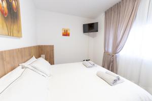 sypialnia z 2 białymi łóżkami i oknem w obiekcie Melannie's Apartment w Bergamo