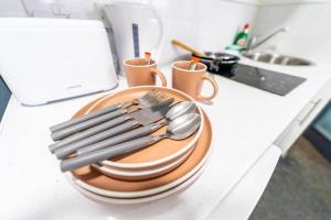 a plate with silver utensils on a counter at Captivating 1-Bed Studio in Birmingham in Birmingham