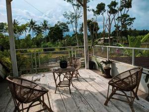 un patio con 3 sillas y una mesa en un porche en Villa Omah Dpartos, en Sleman