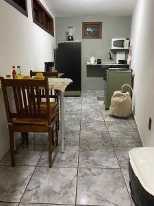- une cuisine avec une table et une chaise dans la chambre dans l'établissement Apartamento Sol Nascente no centro da cidade, à Cruz das Almas