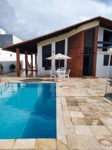 a villa with a swimming pool in front of a house at Casa Leonardo in São Luís