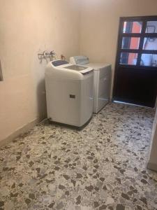 a bathroom with a washer and dryer in a room at Freddy's Suite in Ciudad Nezahualcóyotl