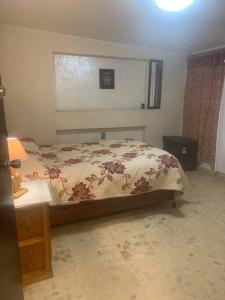 Schlafzimmer mit einem Bett, einem Tisch und einem Fenster in der Unterkunft Freddy's Suite in Ciudad Nezahualcóyotl