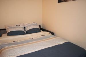 Una cama con dos almohadas encima. en grand studio avec parking à 10 minutes des plages en Lorient