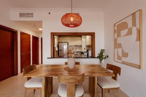 a dining room with a wooden table and chairs at Voyage One Bedroom In Ansam in Abu Dhabi