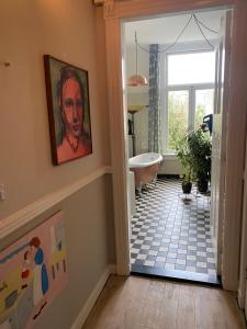 uma casa de banho com banheira e uma pintura na parede em Het huis met de Barbies em Arnhem