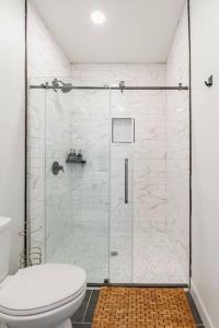 a bathroom with a glass shower with a toilet at 4 Bedroom Bungalow - 5 min to Uptown Charlotte in Charlotte