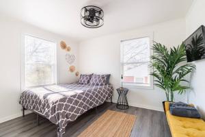 ein Schlafzimmer mit einem Bett und einer Topfpflanze in der Unterkunft 4 Bedroom Bungalow - 5 min to Uptown Charlotte in Charlotte