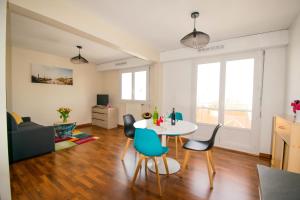 a living room with a table and chairs at grand studio avec parking à 10 minutes des plages in Lorient