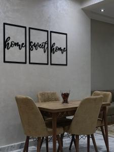 a dining room table with four chairs and the words home sweet home at Home sweet home in El Jadida