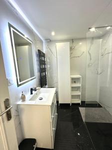 biała łazienka z umywalką i prysznicem w obiekcie Une belle maison avec 2 chambre w mieście Croix