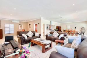 a living room with couches and a table at Luxurious, spacious & central in Sandton