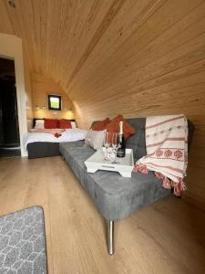 a living room with a couch and a bed at Willow Farm Glamping in Chester