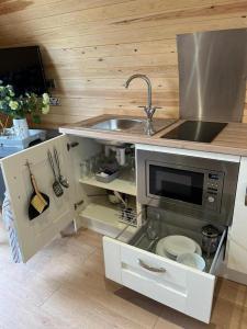 uma cozinha com um lavatório e um micro-ondas em Willow Farm Glamping em Chester