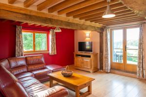 a living room with a couch and a tv at Gîte normand authentique in Roiville