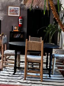 a dining room with a black table and chairs at Dar Tadout in Aït Ourir