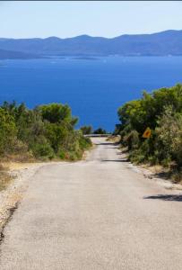 an empty road next to a body of water at IRENA apartment by the beach in Gdinj
