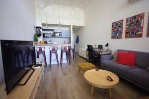 uma sala de estar e cozinha com um sofá e uma mesa em LOFT entero con excelente ubicación, a minutos de AGUADA PARK em Montevidéu