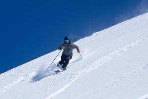 un homme est en train de skier sur une piste enneigée dans l'établissement Departamentos ALOJAMIENTO OFICIAL GRAN PARADOR ski in - out, Centro de Ski El Colorado, Farellones - Único con descuentos en servicios del Centro de Ski, à Farellones