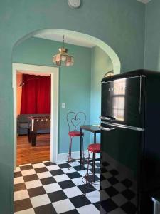 a kitchen with a black refrigerator and a table with stools at Blue Bungalow near OU Med/Downtown in Oklahoma City