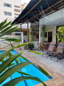 a patio with chairs and a swimming pool at THEMATIC POUSADA in João Pessoa