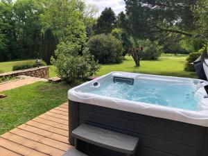 a hot tub sitting on a deck in a yard at Le domaine Aubazen in La Chapelle-Aubareil