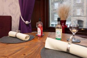 a wooden table with two bottles of wine and glasses at Hawick Haven in Hawick