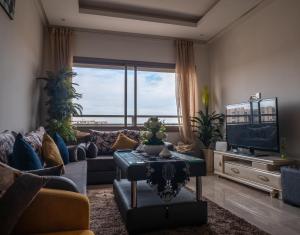 - un salon avec un canapé et une télévision dans l'établissement Luminous & cosy studio - 5 mins from Mohammed V Airport, à Nouaceur