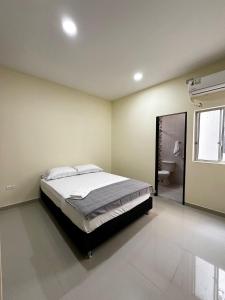 a bedroom with a large bed and a bathroom at Apartamentos Sin fronteras in Leticia