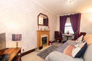 uma sala de estar com uma cama e uma lareira em Hawick Haven em Hawick