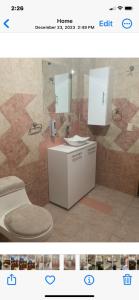 ein Badezimmer mit einem WC, einem Waschbecken und einem Spiegel in der Unterkunft Freddy's Suite in Ciudad Nezahualcóyotl