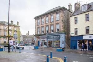 a street in a town with buildings and a store at Hawick Haven in Hawick