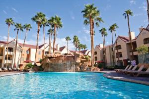 a pool at a resort with palm trees at Holiday Inn Club Vacations at Desert Club Resorts in Las Vegas