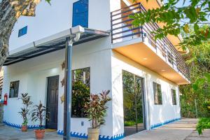 a white house with plants in front of it at Olas Permanentes Buena Vista El Zonte in El Zonte