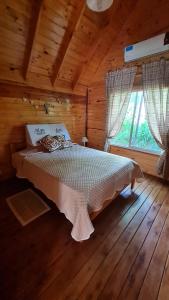 a bedroom with a bed in a log cabin at Cabaña Las Casuarinas del Delta de Tigre in Dique Luján