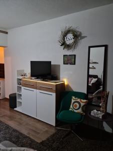 a living room with a tv and a chair at Studio Apartman Ana Doboj in Doboj