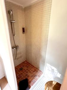 a bathroom with a shower with a red tiled floor at *L'Orangeraie* Maison avec jardin, tennis, parking in Nîmes