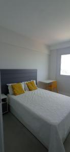 um quarto com uma cama grande e almofadas amarelas em Jaguaribe Praia em Salvador