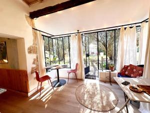 a living room with a table and chairs and large windows at *L'Orangeraie* Maison avec jardin, tennis, parking in Nîmes +16 photos