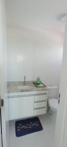 a white bathroom with a sink and a toilet at Jaguaribe Praia in Salvador
