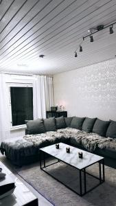 a living room with a couch and a coffee table at Rubin Apartment - moderni huoneisto lähellä keskustaa in Kajaani